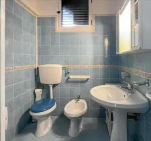 a blue bathroom with a toilet and a sink at Mediterranea in Torre Pali