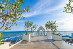 a boardwalk with the ocean in the background at Cham Charm Home Mui Ne in Ấp Thiện Phước