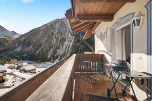 a balcony with a grill and mountains in the background at Ferienwohnung Innerwalten 200 in San Leonardo in Passiria