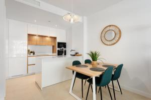a kitchen and dining room with a wooden table and chairs at Horus 054 in Torre del Mar