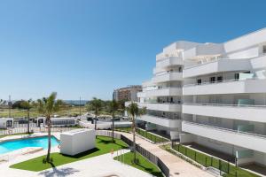 an apartment building with a pool and a parking lot at Horus 054 in Torre del Mar