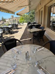 a table with wine glasses on a patio at Logis Hôtel de la Bruyere in Pouzauges