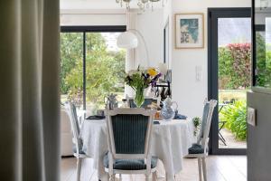 a dining room table with a vase of flowers on it at Chambres D'hôtes Les Goélands in Saint-Cast-le-Guildo