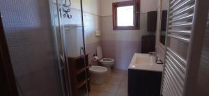 a small bathroom with a toilet and a sink at Villa Fiorita in Budoni