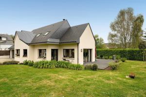 a white house with a gray roof and a yard at Chambres D'hôtes Les Goélands in Saint-Cast-le-Guildo