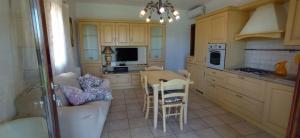 a kitchen with a couch and a table with chairs at Villa Fiorita in Budoni +18 photos