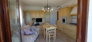 a kitchen with a couch and a table with chairs at Villa Fiorita in Budoni