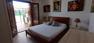 a bedroom with a bed and a sliding glass door at Villa Fiorita in Budoni