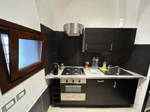 a small kitchen with a stove and a sink at Dammuso Cristoforo Colombo in Pantelleria