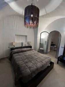 a bedroom with a large bed and a chandelier at Dammuso Cristoforo Colombo in Pantelleria