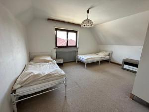 a bedroom with two beds and a window at Haus der Monteure in Stadtbergen