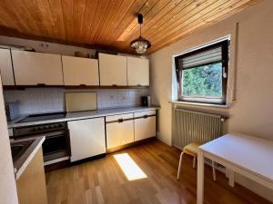 a kitchen with white cabinets and a table and a window at Haus der Monteure in Stadtbergen +9 photos