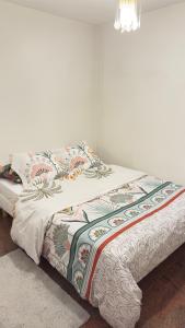 a bed with a blanket on top of it at Le Magnifique 3 personnes Drancy in Drancy