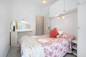 a small bedroom with a bed with a pink blanket at Prealsa Benalmádena in Benalmádena +18 photos