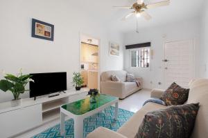 a living room with a tv and a couch and a table at Prealsa Benalmádena in Benalmádena