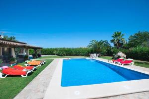 a swimming pool with lounge chairs and a swimming pool at Villa Burgues in Alcudia
