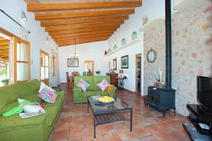 a living room with green furniture and a fireplace at Villa Burgues in Alcudia
