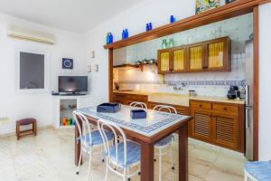 a kitchen with a table and chairs and a tv at Can Blau in Portocolom