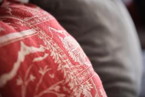 a red pillow with white embroidery on it at Studio Au Pieds Pistes Ski Collet in Allevard