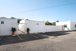 a row of white buildings with plants in a parking lot at Zahora Qg in Barbate