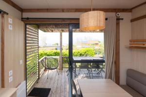 a room with a balcony with a table on a deck at Chalet 25m2 - Pierres Noires in Plouhinec