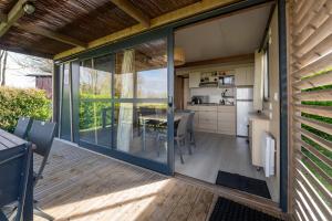 a kitchen and dining area of a house with sliding glass doors at Chalet 25m2 - Pierres Noires in Plouhinec