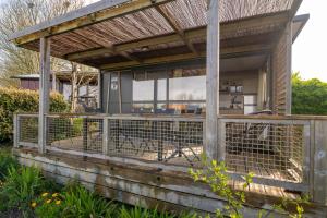 a pergola on the side of a house at Chalet 25m2 - Pierres Noires in Plouhinec