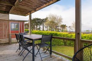 a patio with a table and chairs on a deck at Chalet 25m2 - Pierres Noires in Plouhinec +13 photos