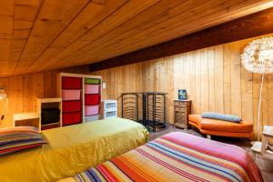 a bedroom with two beds and a tv and a couch at La Cabane d'Ana in Bordeaux