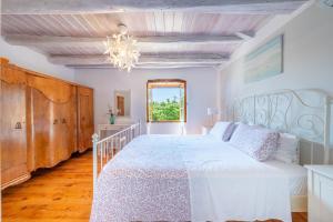 a bedroom with a white bed and a window at Villa Iremia Antipaxos in Antipaxos +26 photos