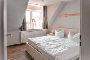 a bedroom with a white bed and a window at Lagunenstadt am Haff - Fewo 157 Haffblick in Ueckermünde