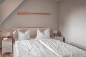 a bedroom with a bed with white sheets and pillows at Lagunenstadt am Haff - Fewo 157 Haffblick in Ueckermünde