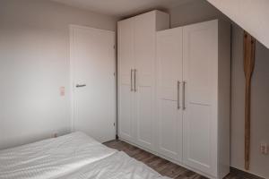 a bedroom with white cabinets and a bed at Lagunenstadt am Haff - Fewo 157 Haffblick in Ueckermünde
