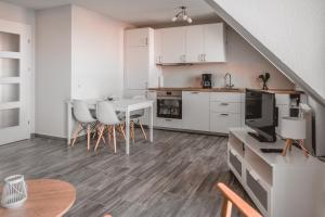 a kitchen with white cabinets and a table and chairs at Lagunenstadt am Haff - Fewo 157 Haffblick in Ueckermünde