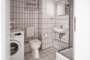 a bathroom with a toilet a sink and a washing machine at Lagunenstadt am Haff - Fewo 157 Haffblick in Ueckermünde +15 photos
