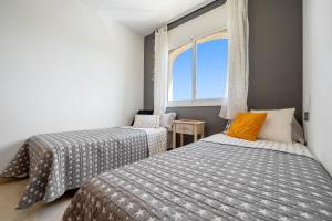 two beds in a room with a window at Montserrat in Miami Platja +20 photos