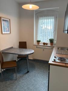 a kitchen with a table and chairs and a window at Wohnung Weida 2 in Riesa