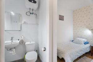a bathroom with a toilet and a sink and a bed at La Estrella in Hermigua