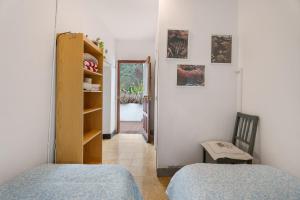 a bedroom with two beds and a chair and a mirror at La Estrella in Hermigua