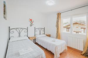 a bedroom with two beds and a window at Los Mirlos in Navaluenga