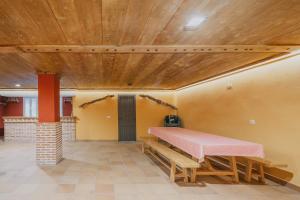 a room with a pink table and benches at Los Mirlos in Navaluenga