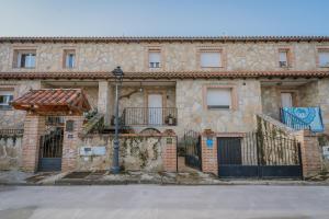 an old stone building with a gate and a street light at Los Mirlos in Navaluenga