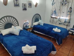 two beds in a room with blue and white sheets at Agroturismo El Serrano in Moratalla