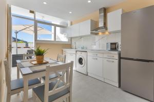 a kitchen with white appliances and a table and chairs at Cala Sunrise in Los Realejos