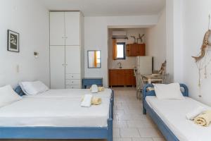 two beds in a room with a kitchen at Perasma Studios 7 in Kipri