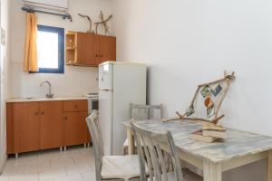 a kitchen with a table and a refrigerator at Perasma Studios 7 in Kipri +12 photos