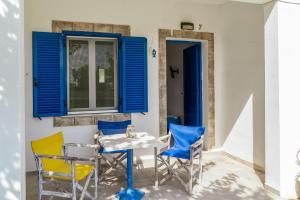 a table and chairs on a patio with blue shutters at Perasma Studios 7 in Kipri