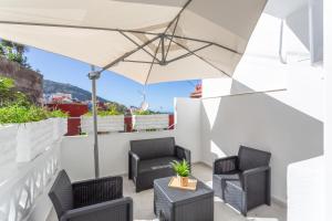 a patio with two chairs and an umbrella at Cala Sunrise in Los Realejos