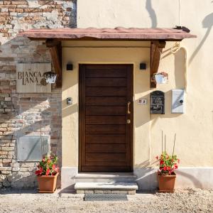 a door of a building with two potted plants at Bed and breakfast Biancalana in Petritoli