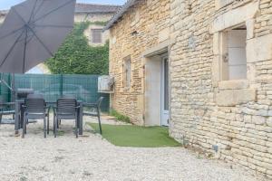 a patio with a table and chairs and an umbrella at Gite Berclois in Bercloux